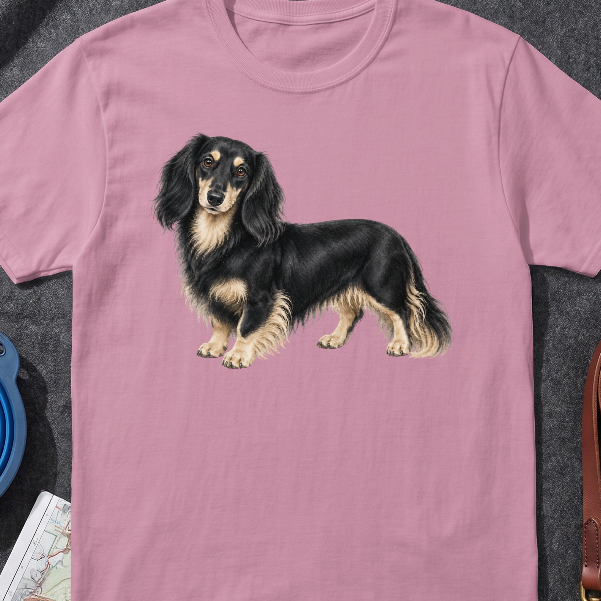 Long-haired black and tan dachshund illustration on a pink t-shirt.