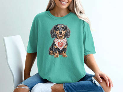 Dachshund wearing a heart bandana, printed on a teal t-shirt.