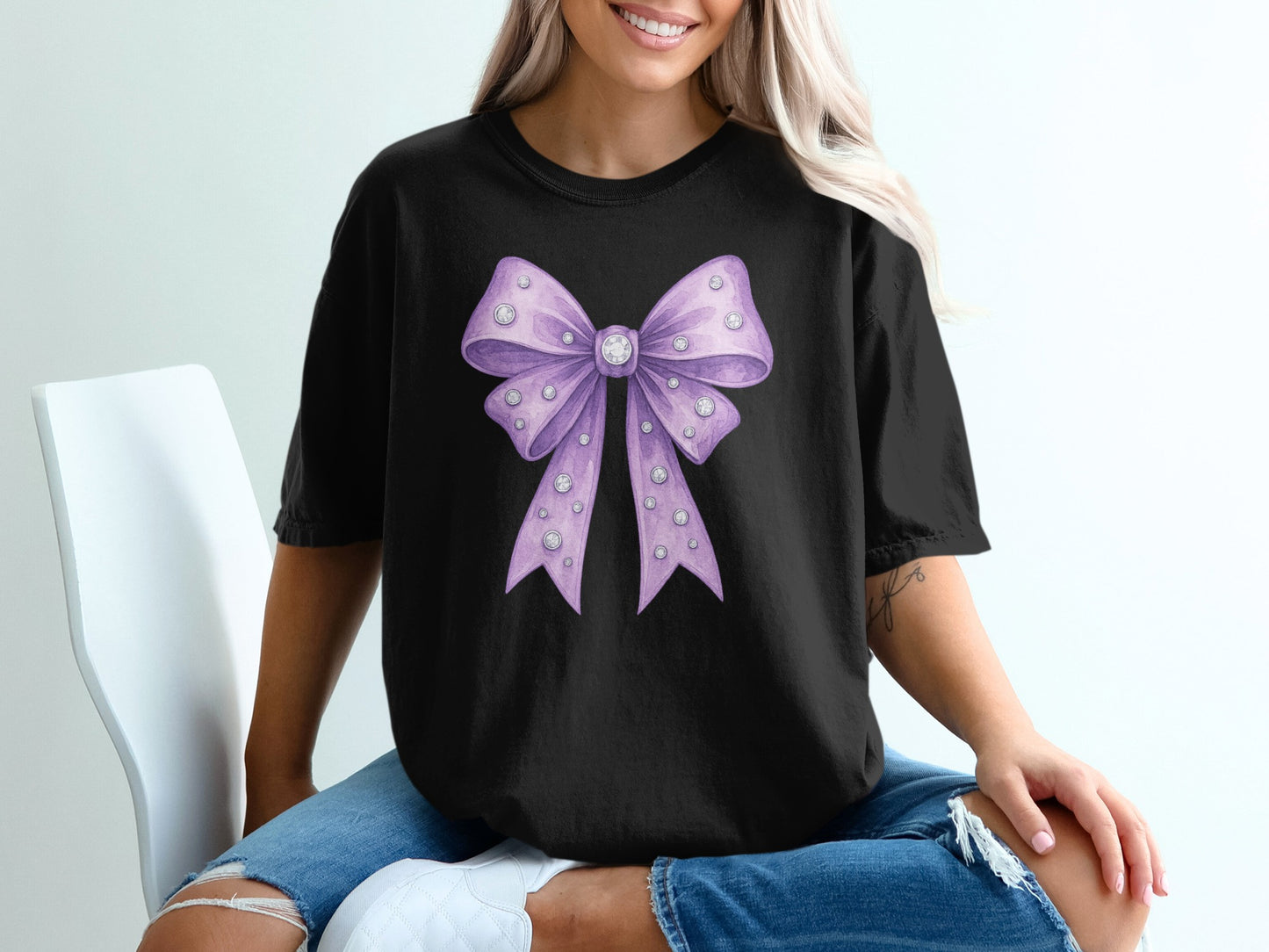 Black t-shirt featuring a large purple bow with gem accents.