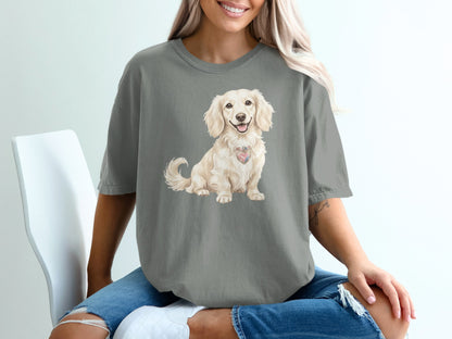Cream-colored dachshund with heart-shaped tag on grey t-shirt.