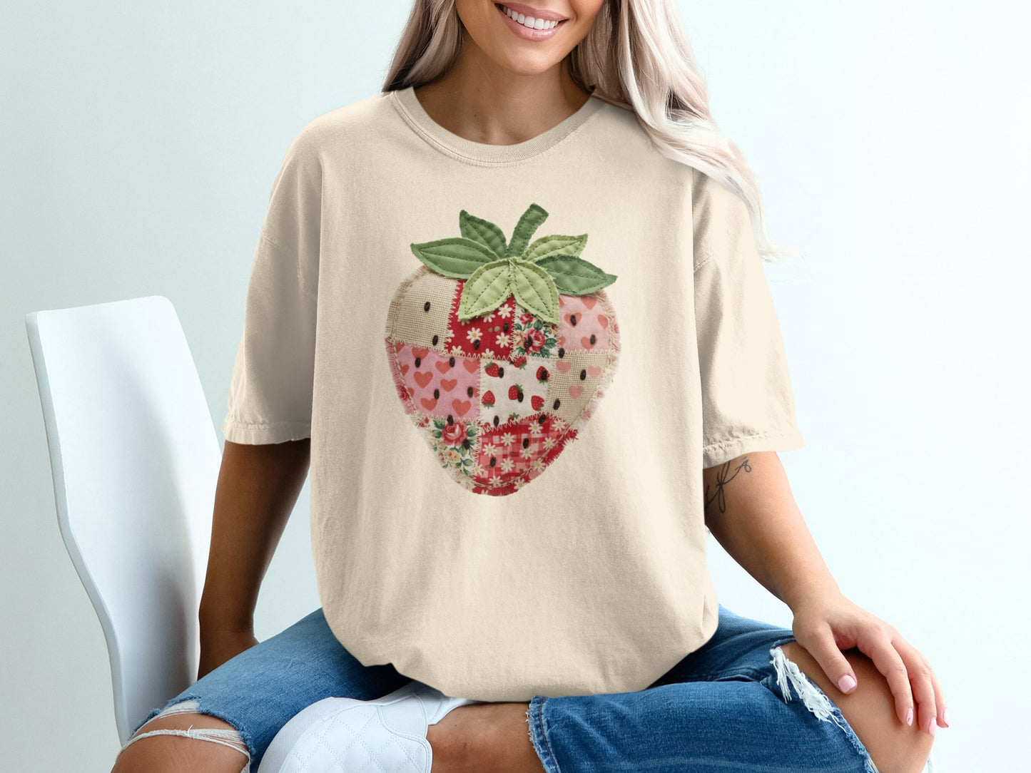 Cream t-shirt with a fabric patchwork strawberry graphic.