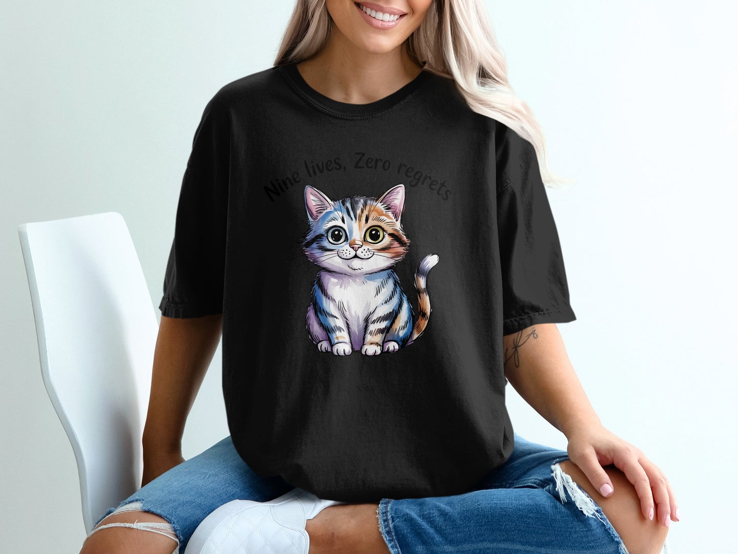 Black t-shirt with a cartoon cat and text "Nine lives, zero regrets".