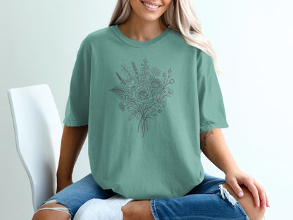 Teal t-shirt with a line drawing of a floral bouquet on the chest.