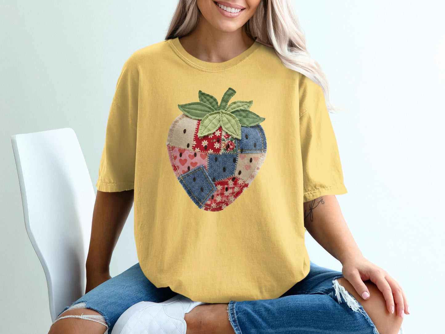 Yellow t-shirt with a patchwork strawberry graphic on the front.
