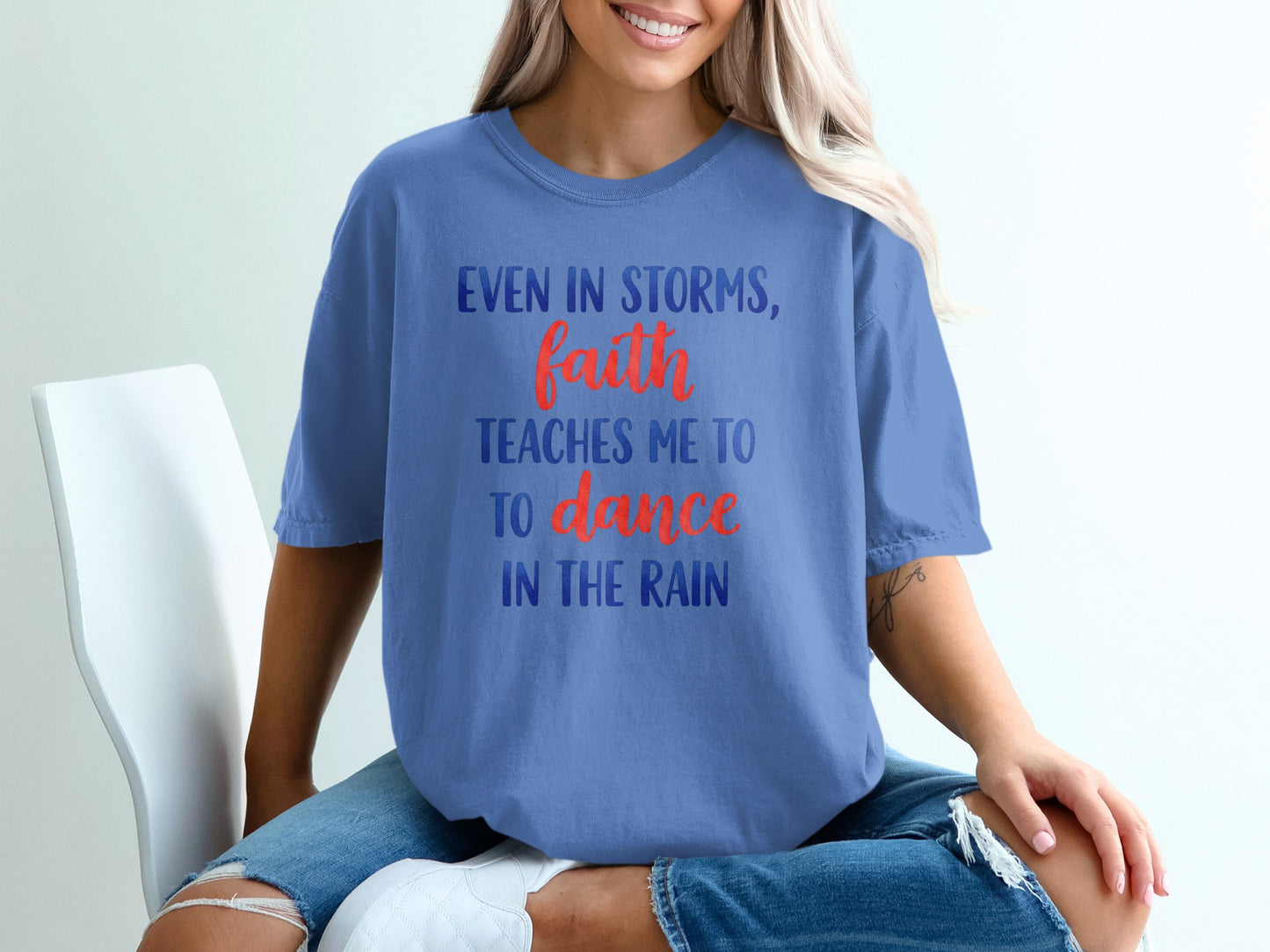 Blue t-shirt with "Even in storms, faith teaches me to dance in the rain" text.