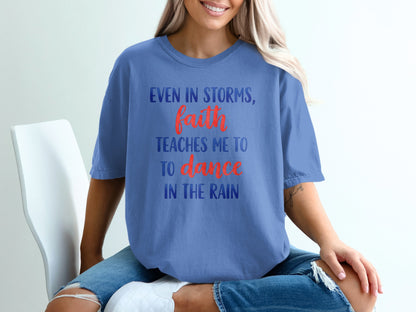Blue t-shirt with "Even in storms, faith teaches me to dance in the rain" text.