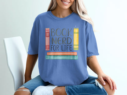 Blue t-shirt with stacked colorful books and "BOOK NERD FOR LIFE" text.