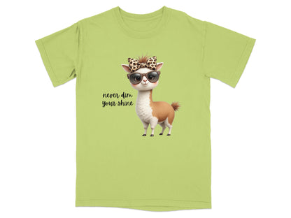 Lime green t-shirt with a cartoon llama wearing sunglasses and a bow, "never dim your shine" text.