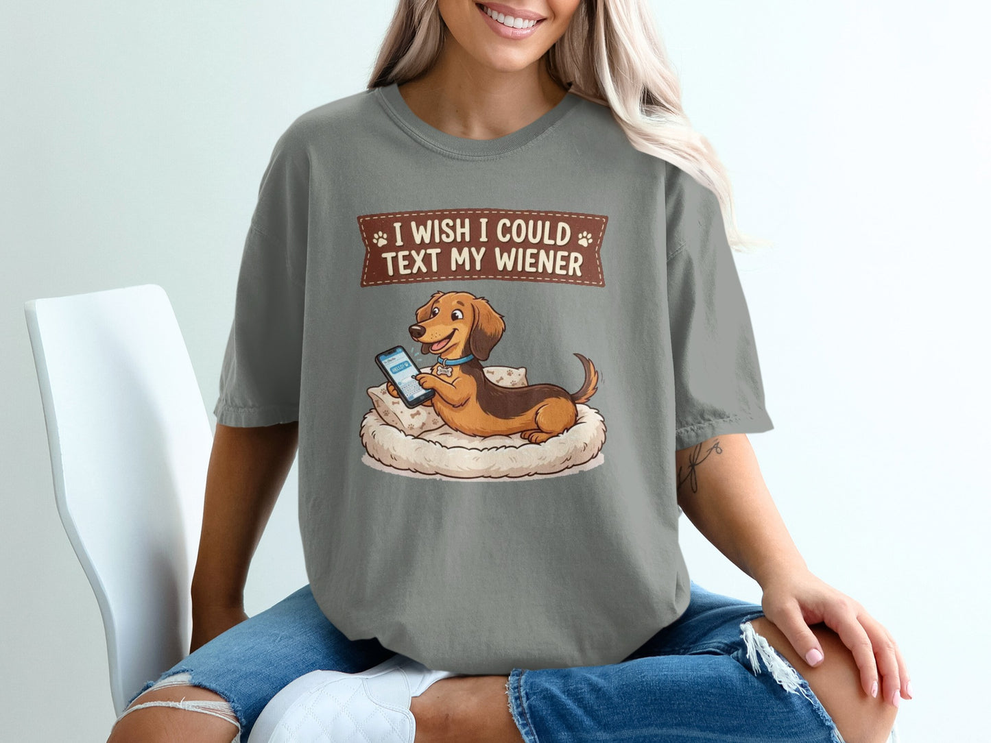 Dachshund wearing collar on pillow, texting on phone, text "I wish I could text my wiener".