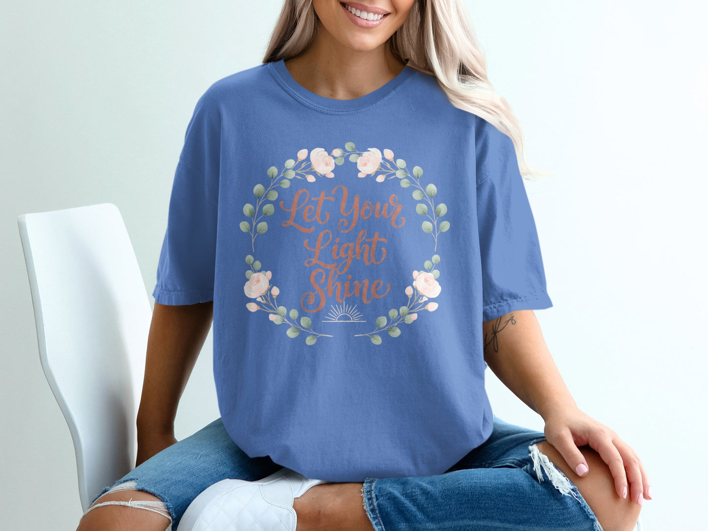 Blue t-shirt with floral wreath and "Let Your Light Shine" text.