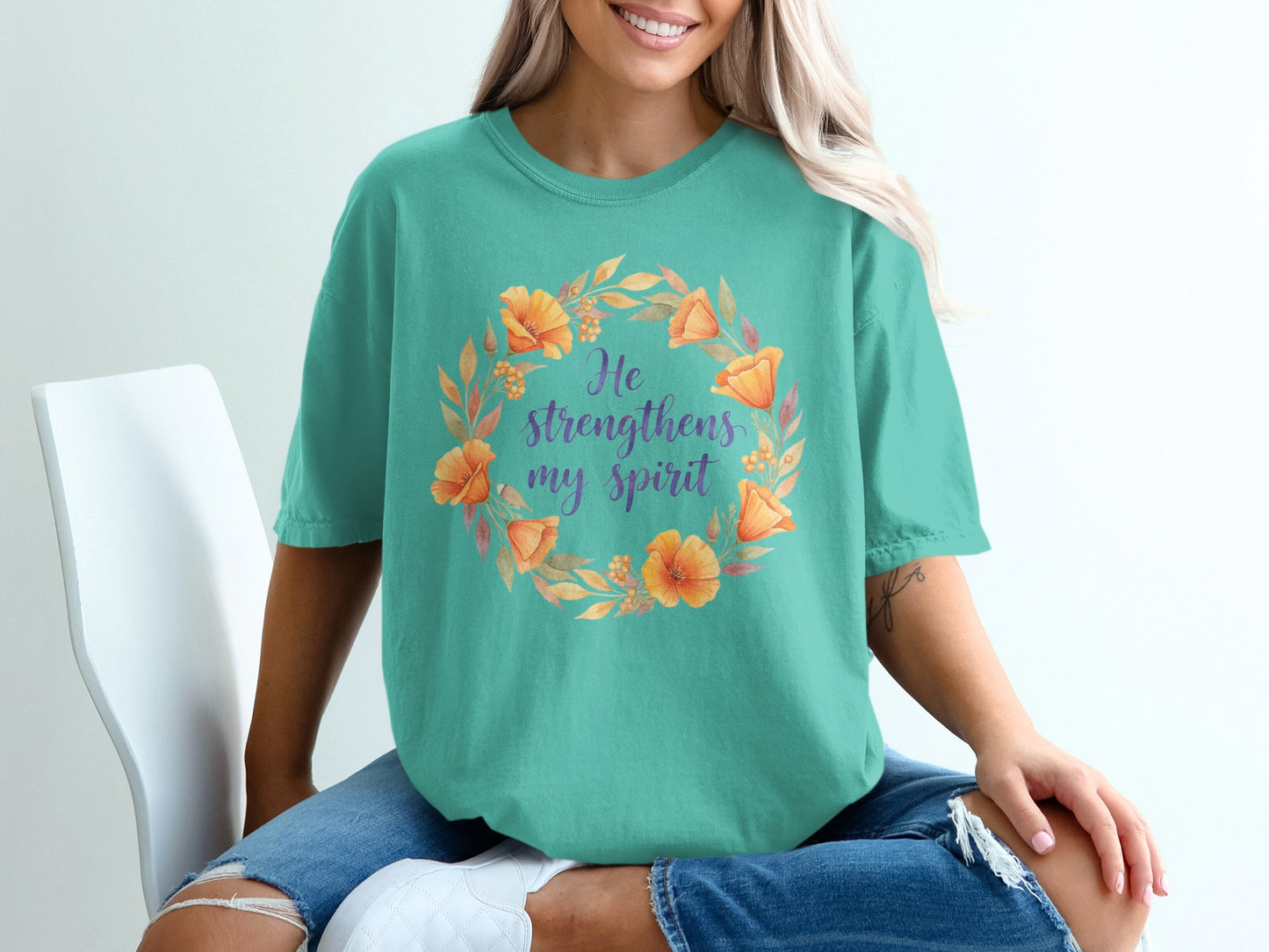 Teal t-shirt with floral wreath and text "He strengthens my spirit".