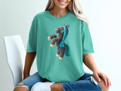 Teal t-shirt with a crocheted horse illustration on the chest.
