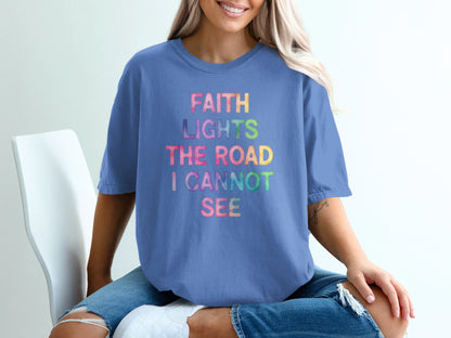 Purple t-shirt with rainbow text "FAITH LIGHTS THE ROAD I CANNOT SEE".