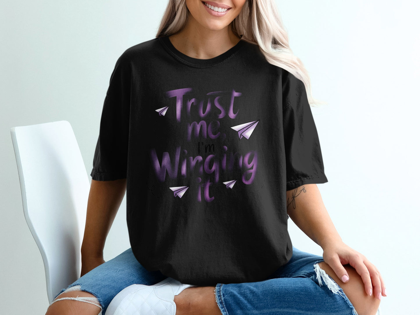 Black t-shirt with purple text "Trust me, I'm Winging It" and paper airplanes.