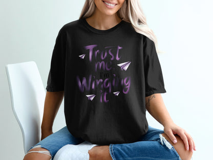 Black t-shirt with purple text "Trust me, I'm Winging It" and paper airplanes.