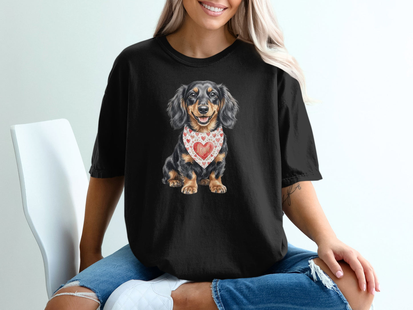 Black t-shirt featuring a long-haired dachshund wearing a heart-patterned bandana.