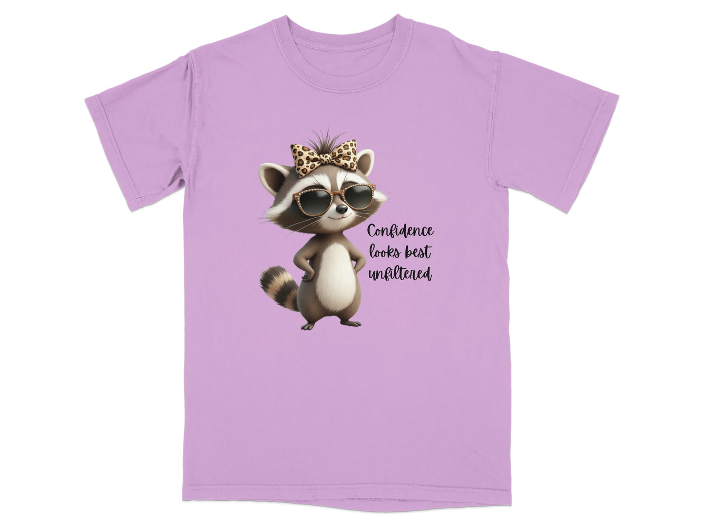 Lavender t-shirt with a raccoon wearing sunglasses and a bow, text says "Confidence looks best unfiltered".