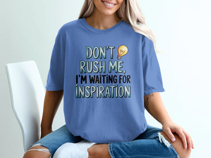 Blue t-shirt with "DON'T RUSH ME, I'M WAITING FOR INSPIRATION" text and lightbulb graphic.