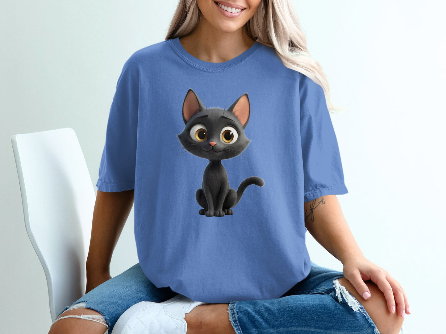 T-shirt featuring a smiling cartoon black cat with big yellow eyes.