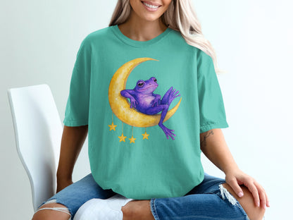 Purple frog sitting on a crescent moon with yellow stars.