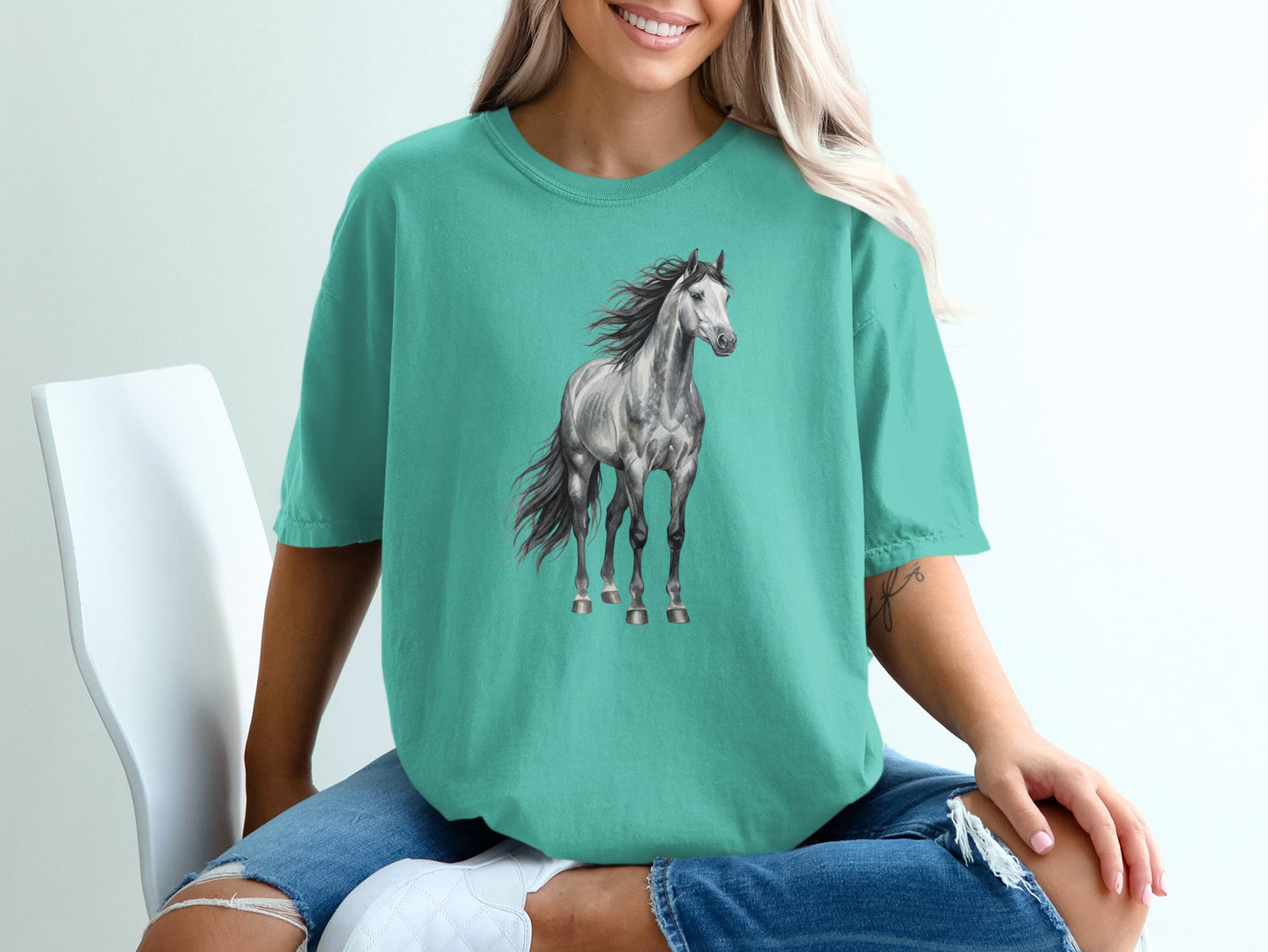 Teal t-shirt featuring a light grey horse with a flowing mane.