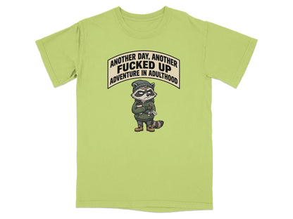 Green t-shirt with raccoon graphic and text "Another day, another fucked up adventure in adulthood".