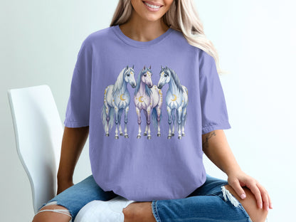 Three stylized horses with celestial accents on a purple t-shirt.