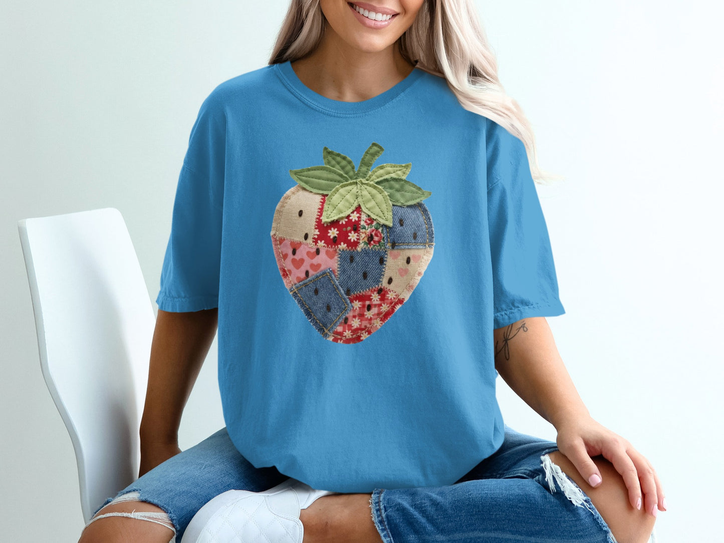 Blue t-shirt with a patchwork strawberry graphic.