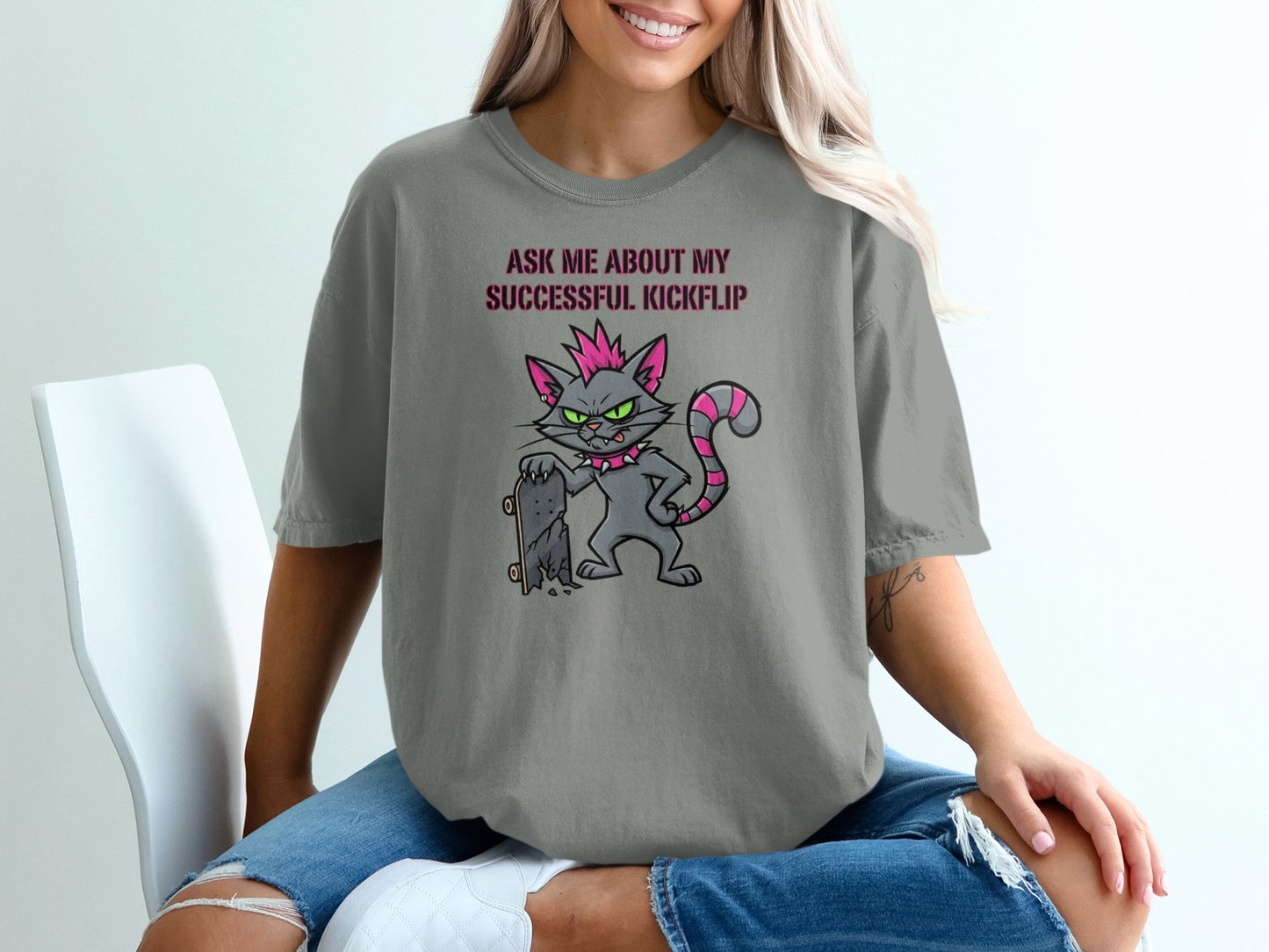 Gray t-shirt with cartoon cat holding skateboard, text "ASK ME ABOUT MY SUCCESSFUL KICKFLIP".