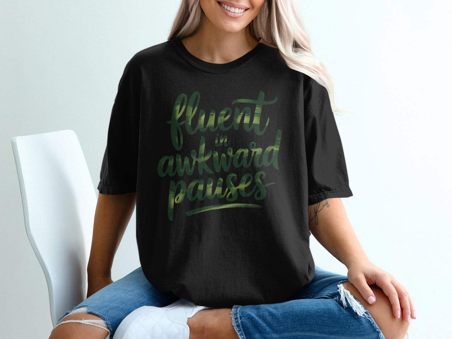 Black t-shirt with "fluent awkward pauses" text in green.