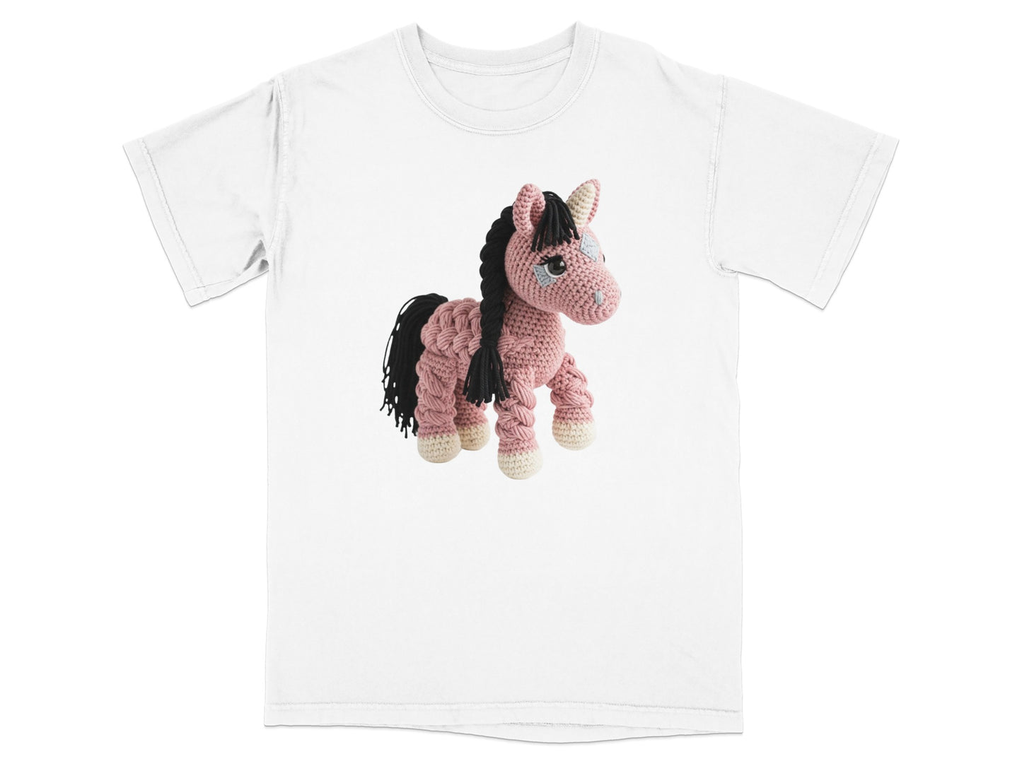 Crocheted pink horse toy with black mane and tail on white t-shirt.