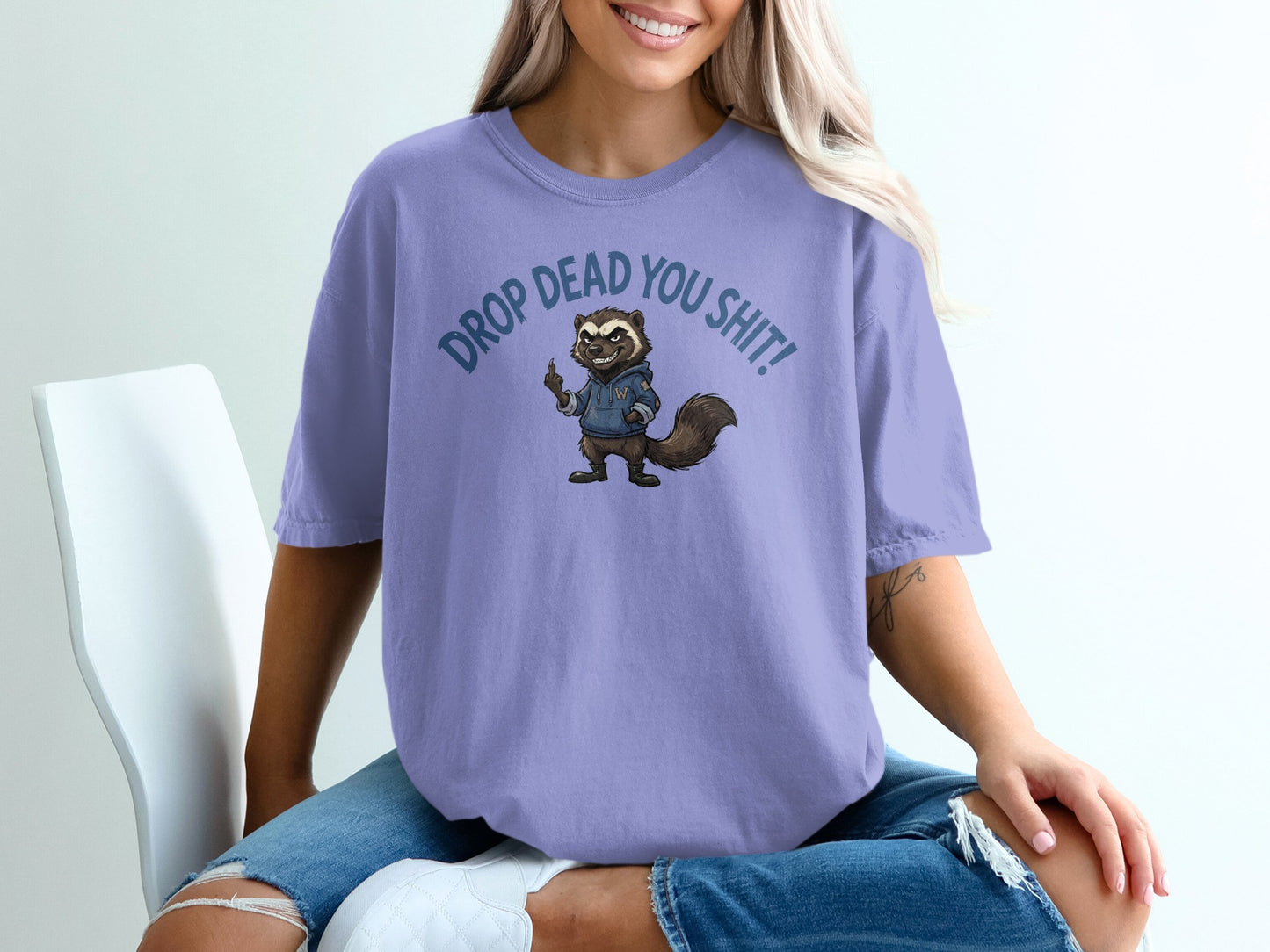 Purple t-shirt with cartoon raccoon saying "DROP DEAD YOU SHIT".