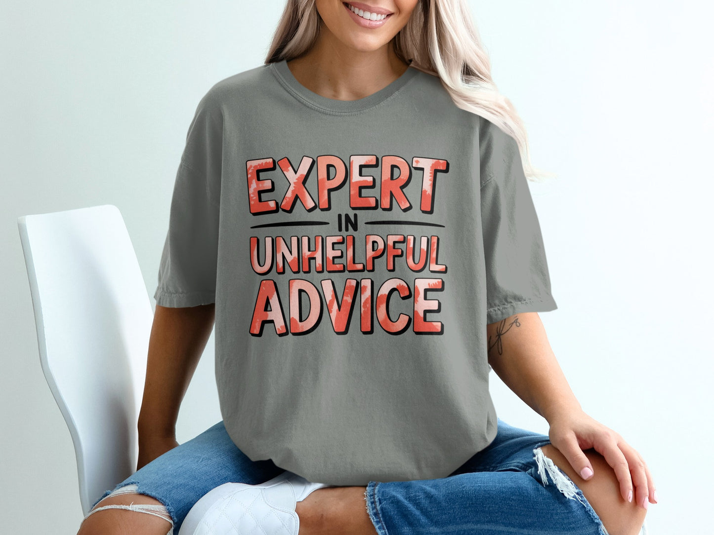 Gray t-shirt with "EXPERT IN UNHELPFUL ADVICE" printed in red and white lettering.