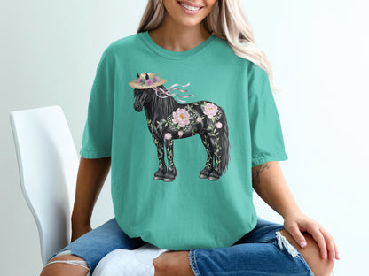 Black horse with floral accents and straw hat on teal t-shirt.