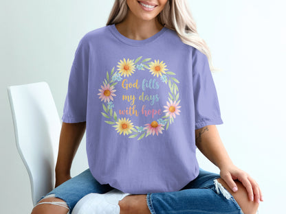 Lavender t-shirt with floral wreath and text "God fills my days with hope".