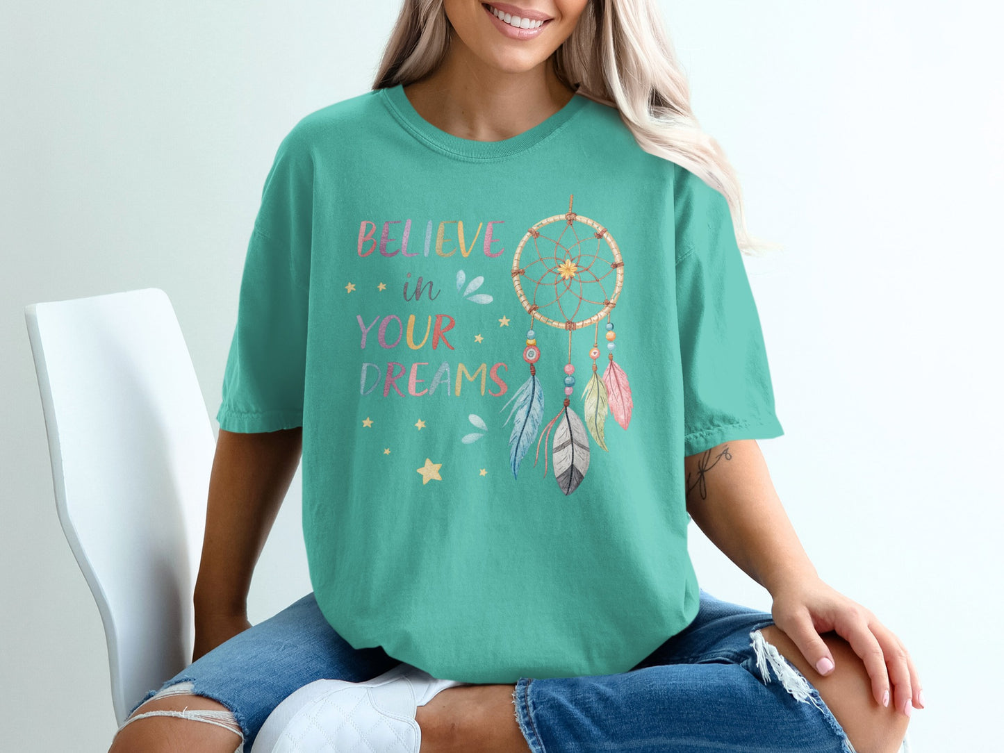 Teal t-shirt with "Believe in your dreams" and dreamcatcher graphic.