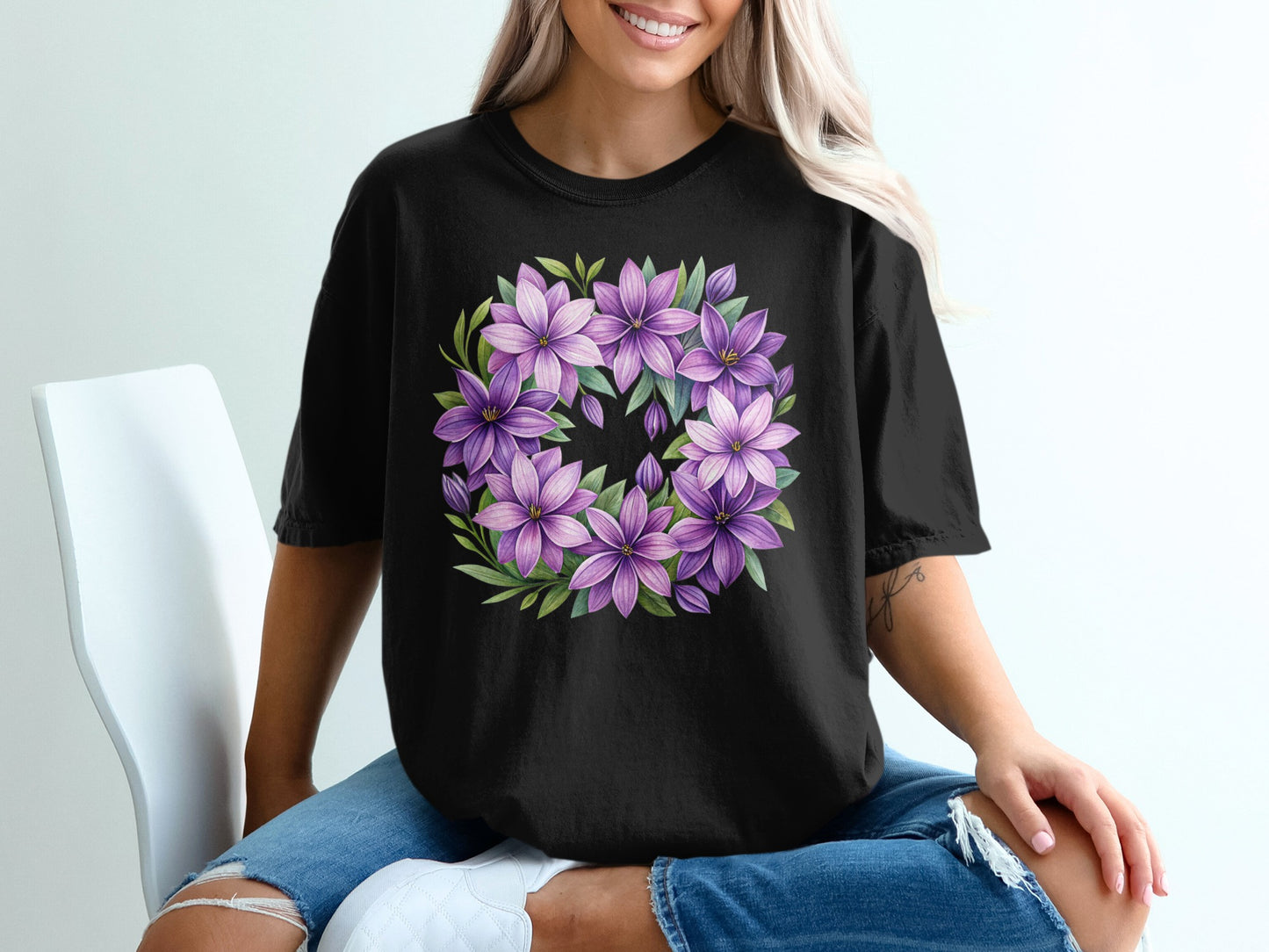 Black t-shirt with a circular wreath of purple flowers.