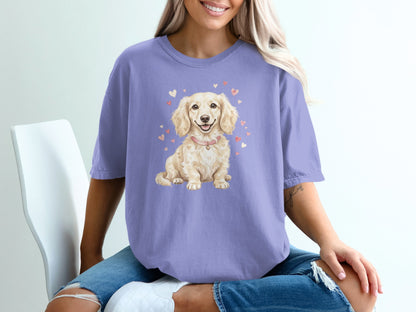 Lavender t-shirt with a small, light-colored dog wearing a pink collar surrounded by hearts.