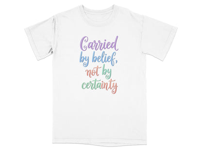 White t-shirt with "Carried by belief, not by certainty" text.