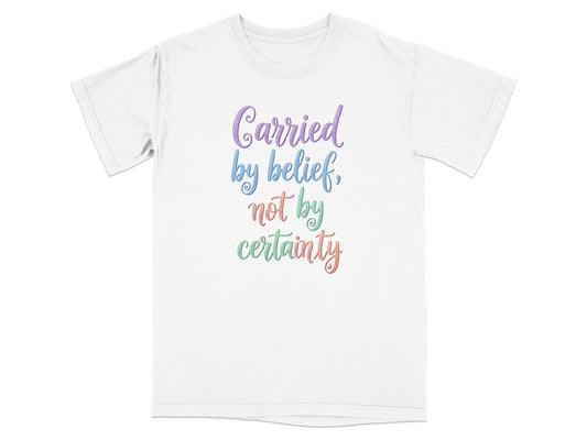 White t-shirt with "Carried by belief, not by certainty" text.