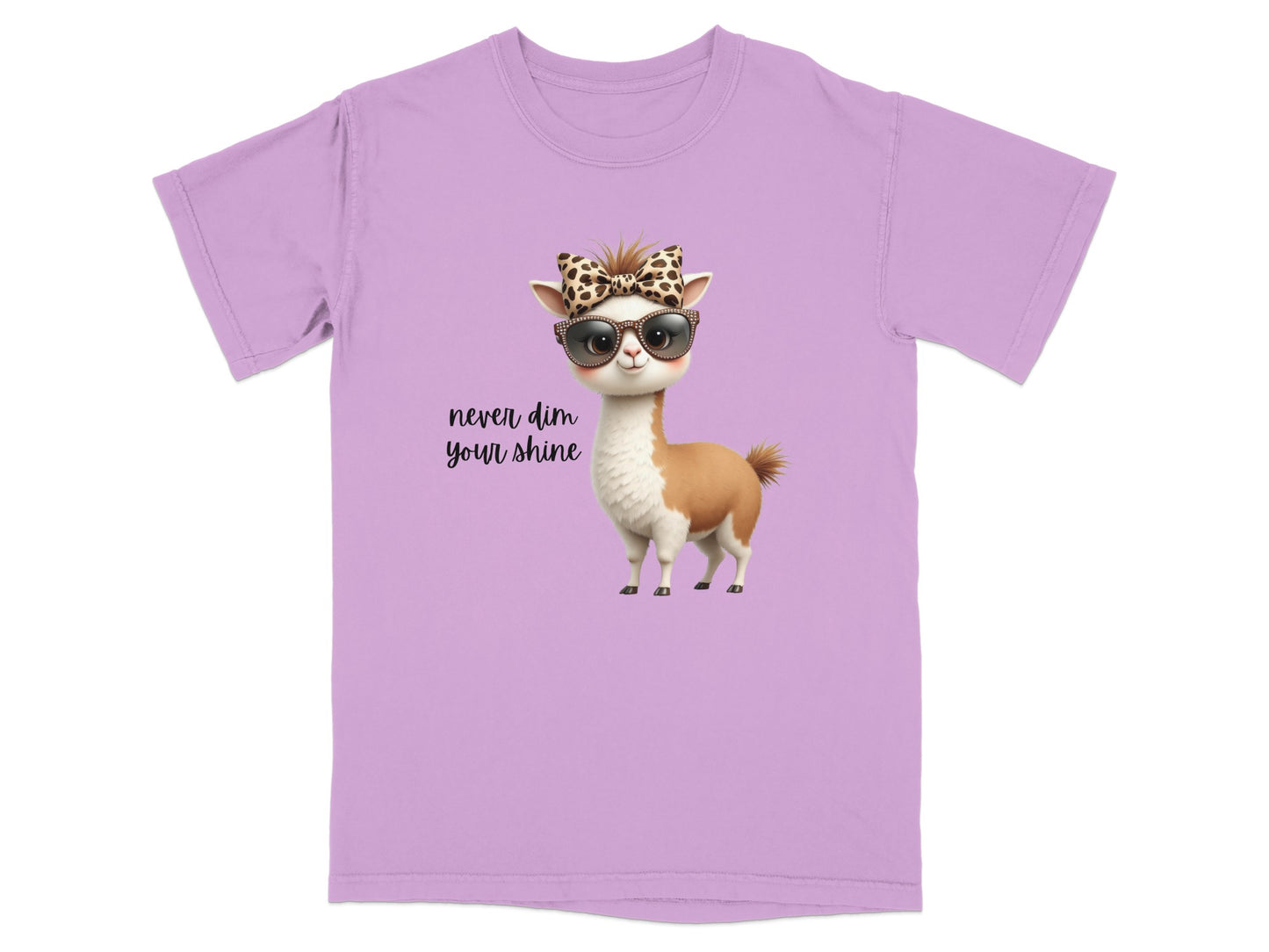 Lilac t-shirt with a cartoon llama wearing sunglasses and a bow, "Never dim your shine."