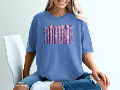 Purple t-shirt with a watercolor illustration of a row of antique books.