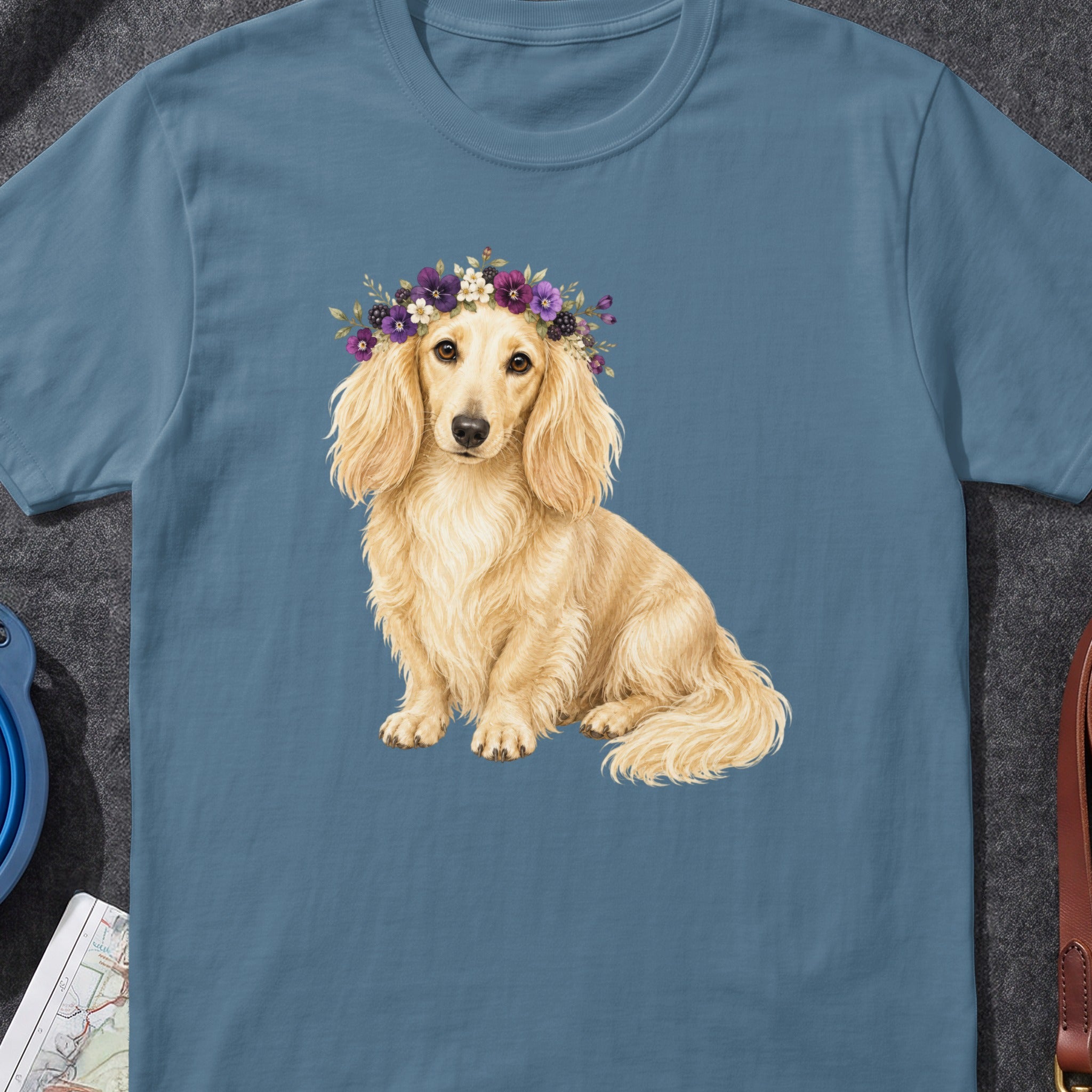 Dachshund wearing a floral crown on a blue t-shirt.