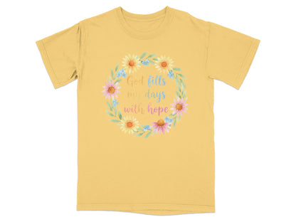 Yellow t-shirt with a floral wreath and the text "God fills my days with hope".