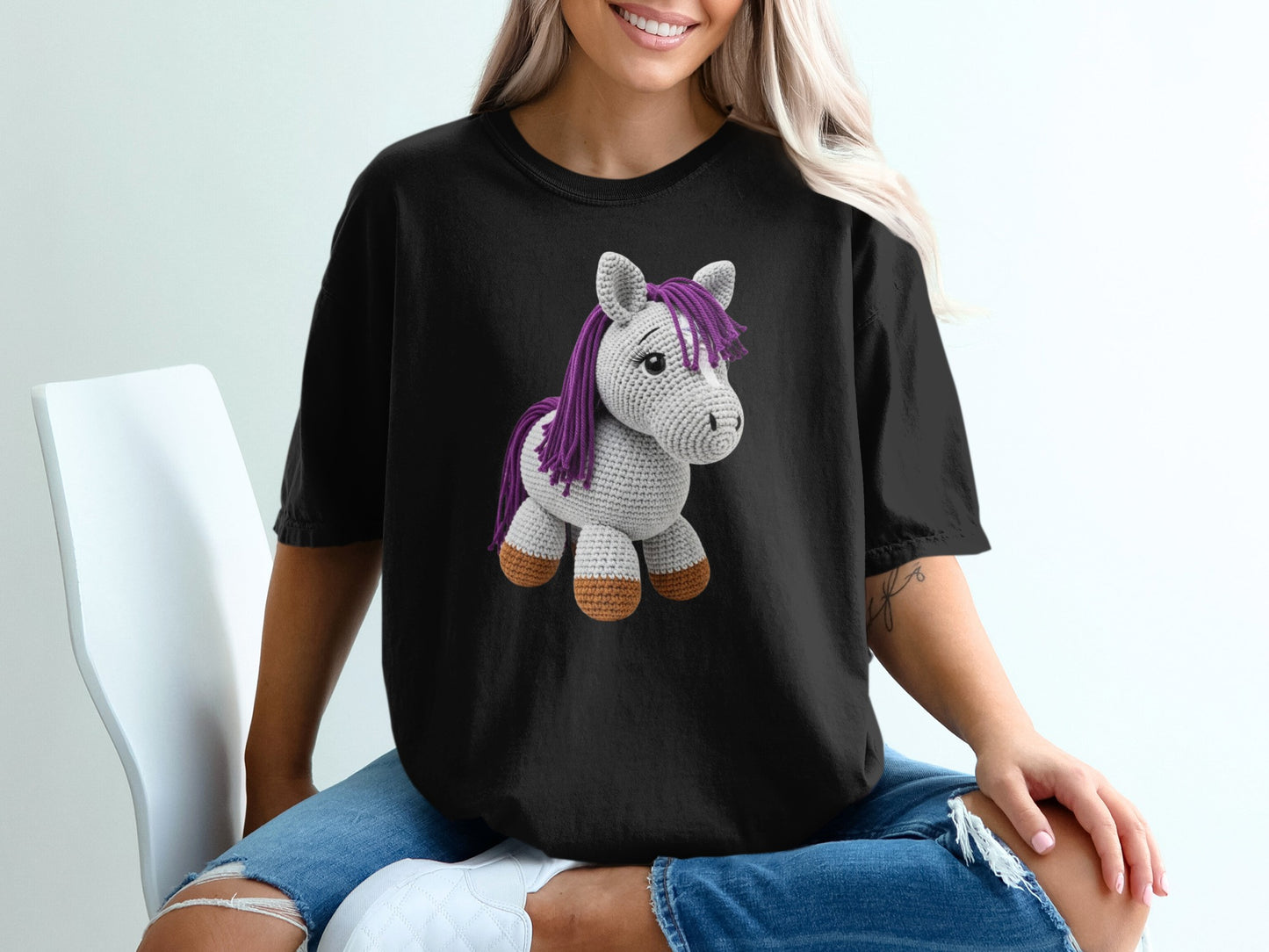 Black t-shirt with a crochet unicorn graphic on the front.