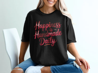 Black t-shirt with "Happiness is Handmade Daily" in gradient pink lettering.