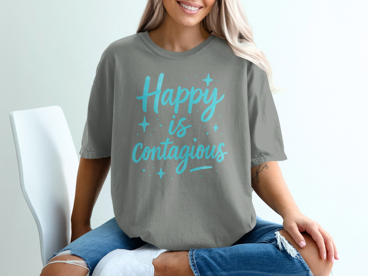Grey t-shirt with "Happy is Contagious" text in blue.