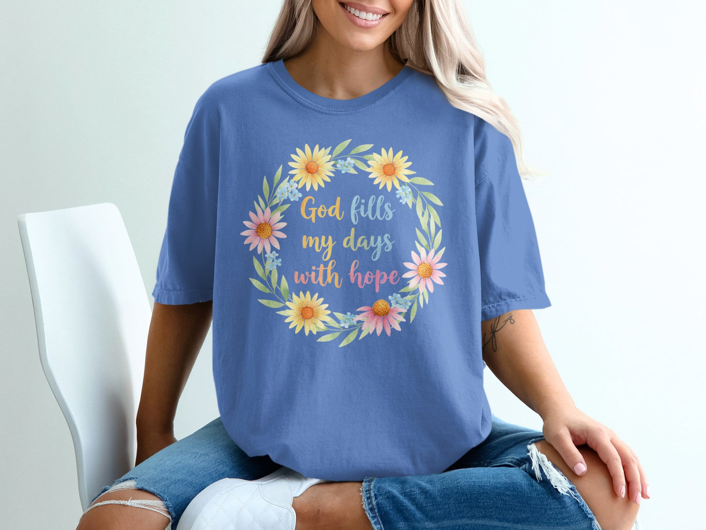 Blue t-shirt with floral wreath and "God fills my days with hope" text.
