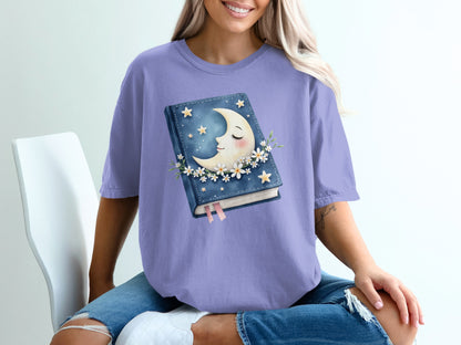 Purple t-shirt with a book, moon, and stars graphic.