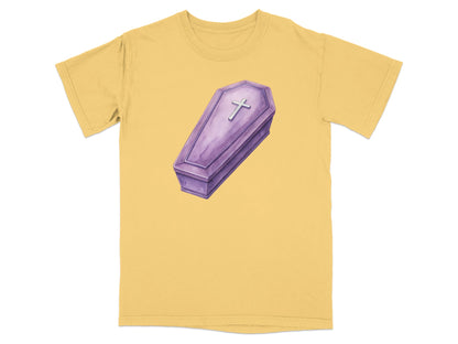 Yellow t-shirt with a watercolor illustration of a purple coffin with a silver cross.
